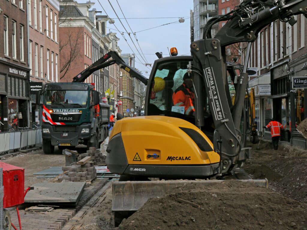 Straatwerkzaamheden en werkzaamheden in de Ferdinand Bolstraat met bouwmachines en graafmachines.